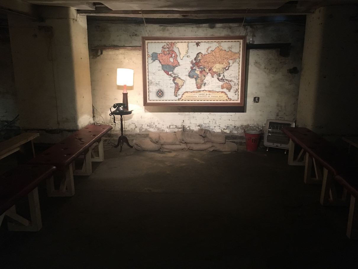 Play setting: a room with a map on the wall and a bench.